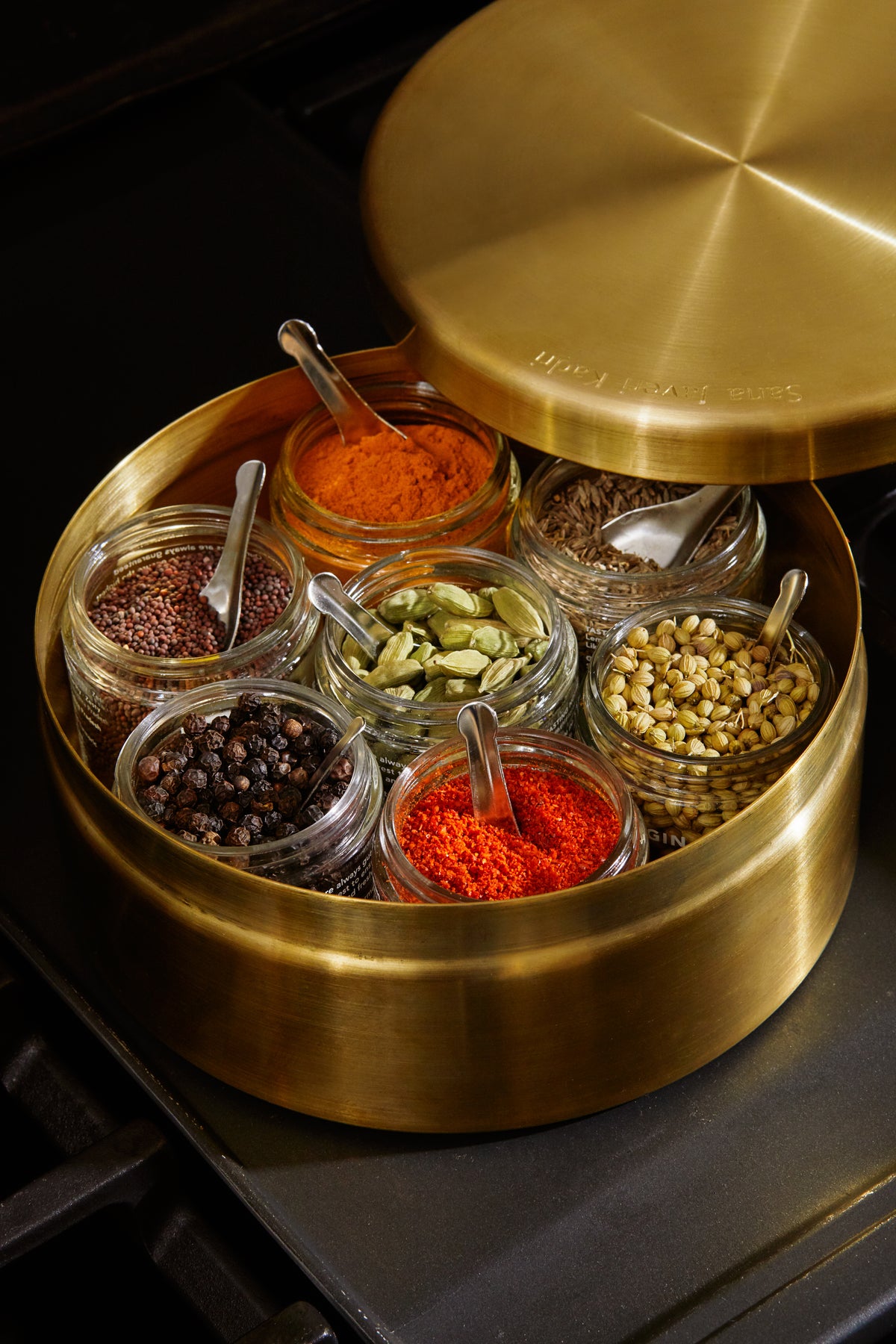 Diaspora masala dabba with essential spices in glass jars in it 