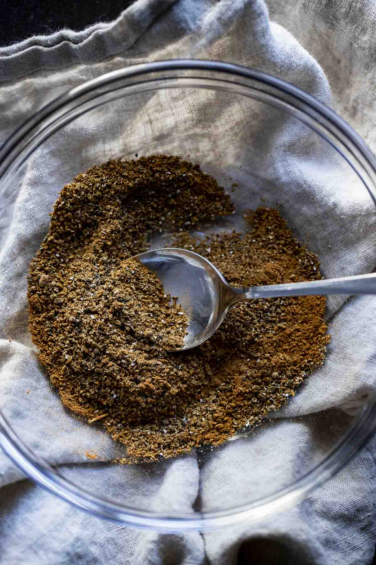 garam masala in a glass bowl with a spoon in it